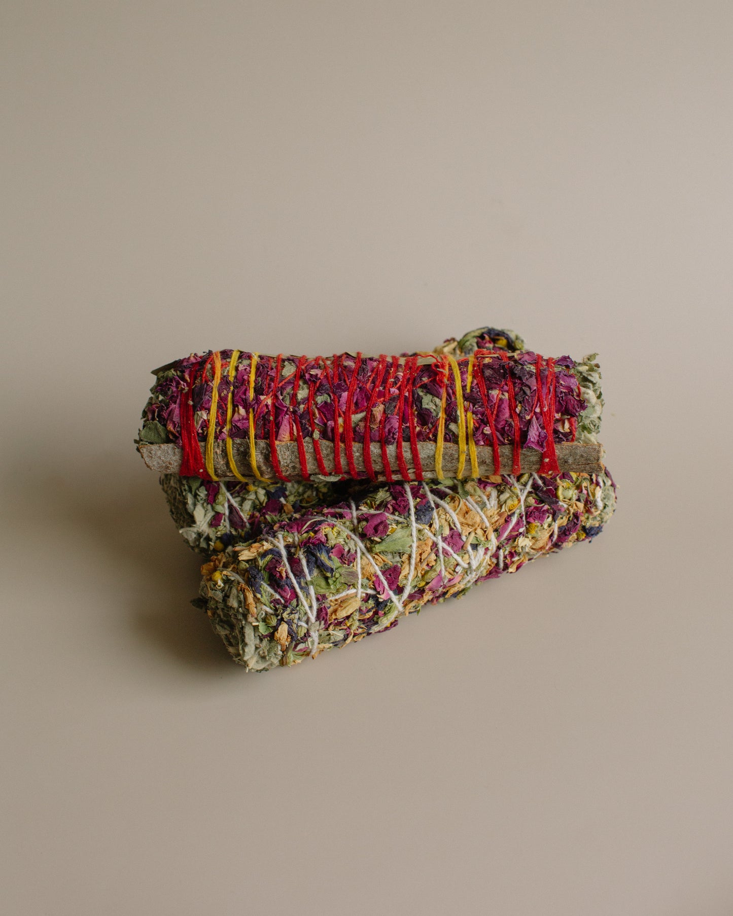 Stack of colorful Havan and Rose Smoke Bindles on a beige background