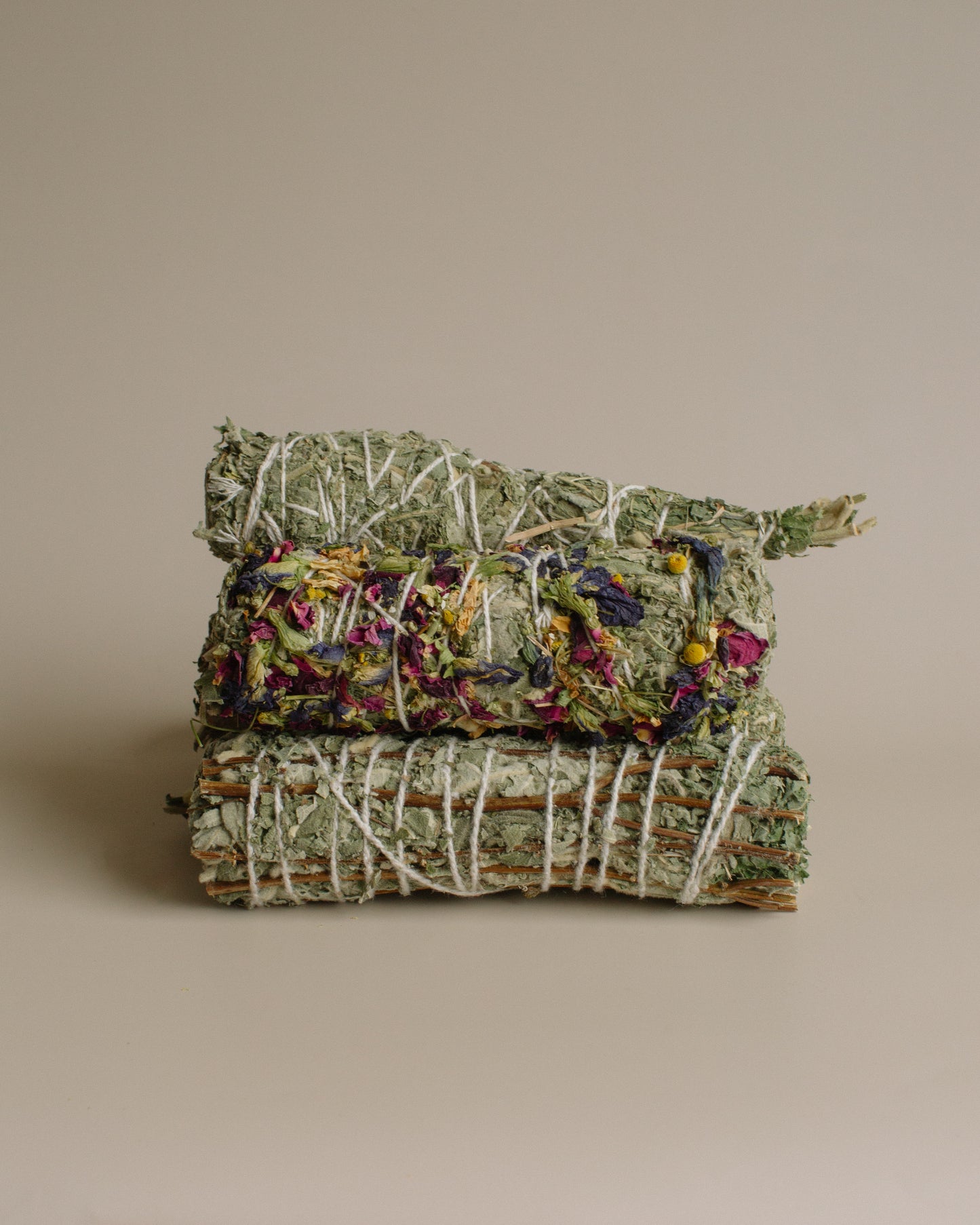 Stack of dried herbs tied together on a beige background