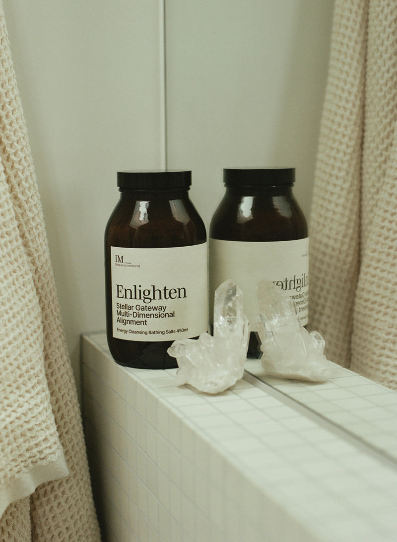 IM_Enlighten_Bath_salts for stellar gateway connection in bathroom with mirror waffle towel clear quartz. Amber bottle with white label. tiled bathroom