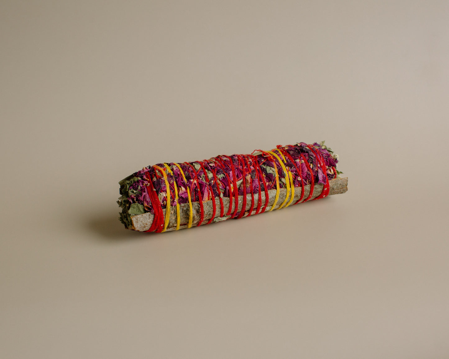 Rolled havan sage with colorful ribbons on a beige background
