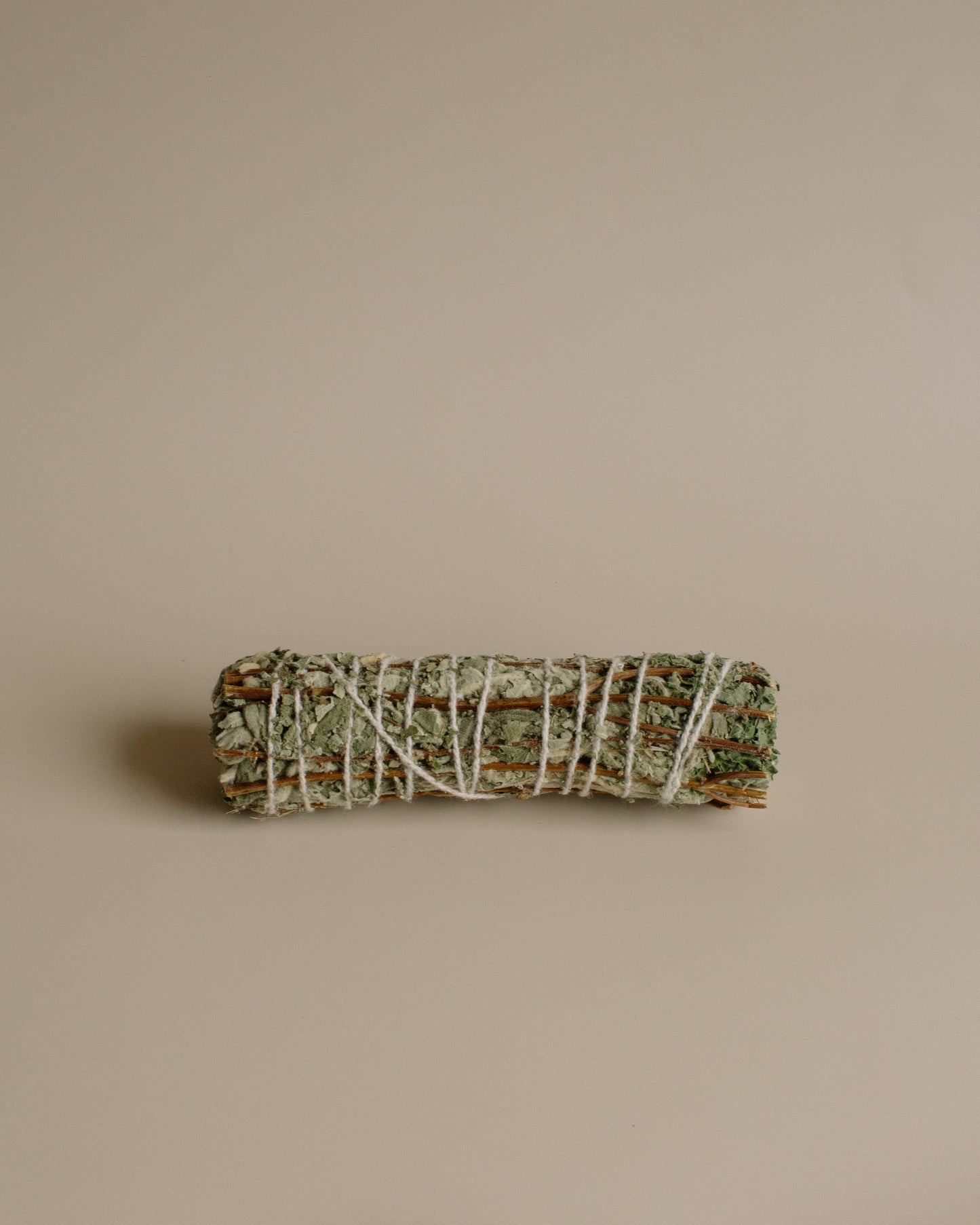 Bundled sage and Tulsi stick on a beige background