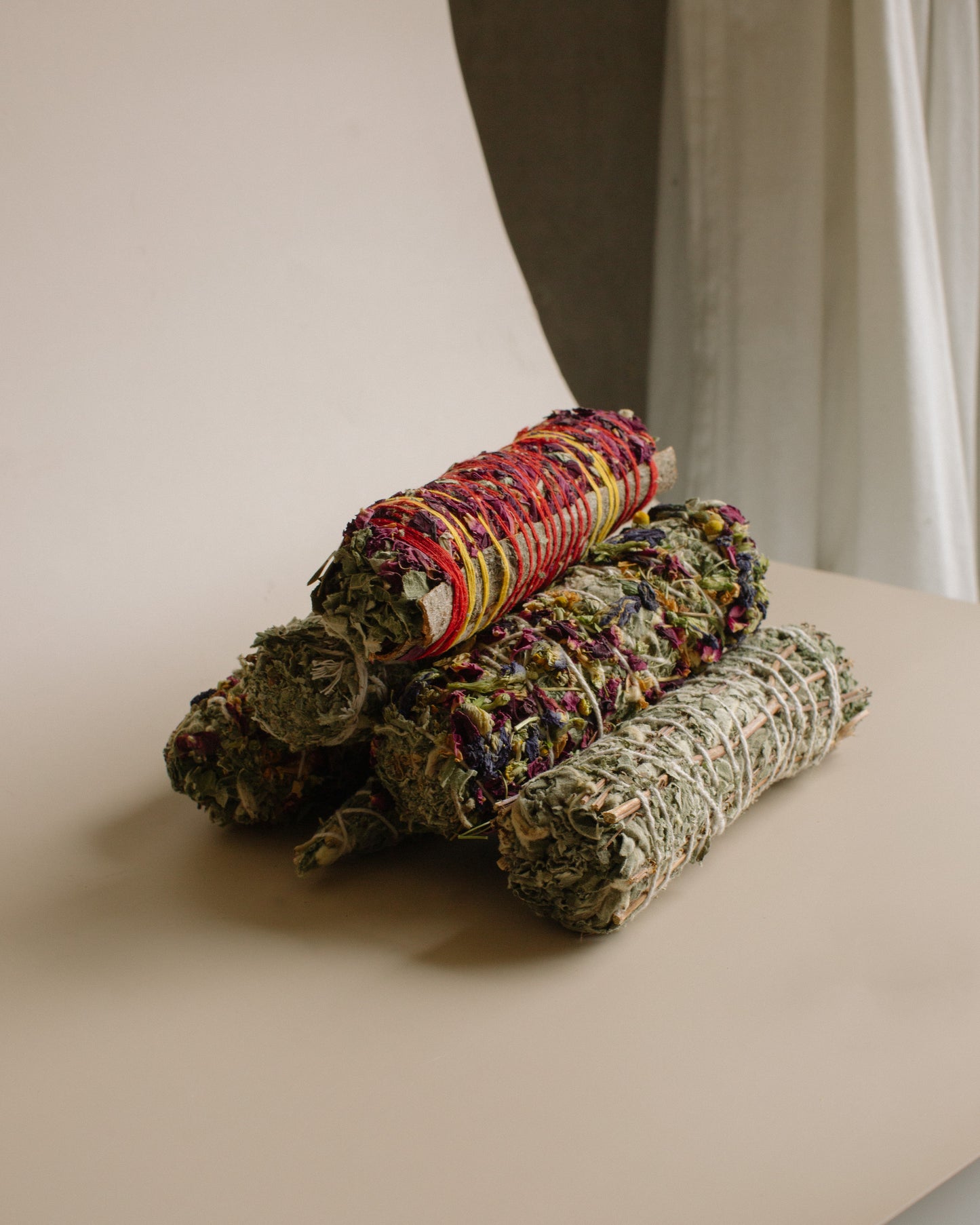 Three Herbal Smoke Bundles stacked, on a light surface with a neutral background.