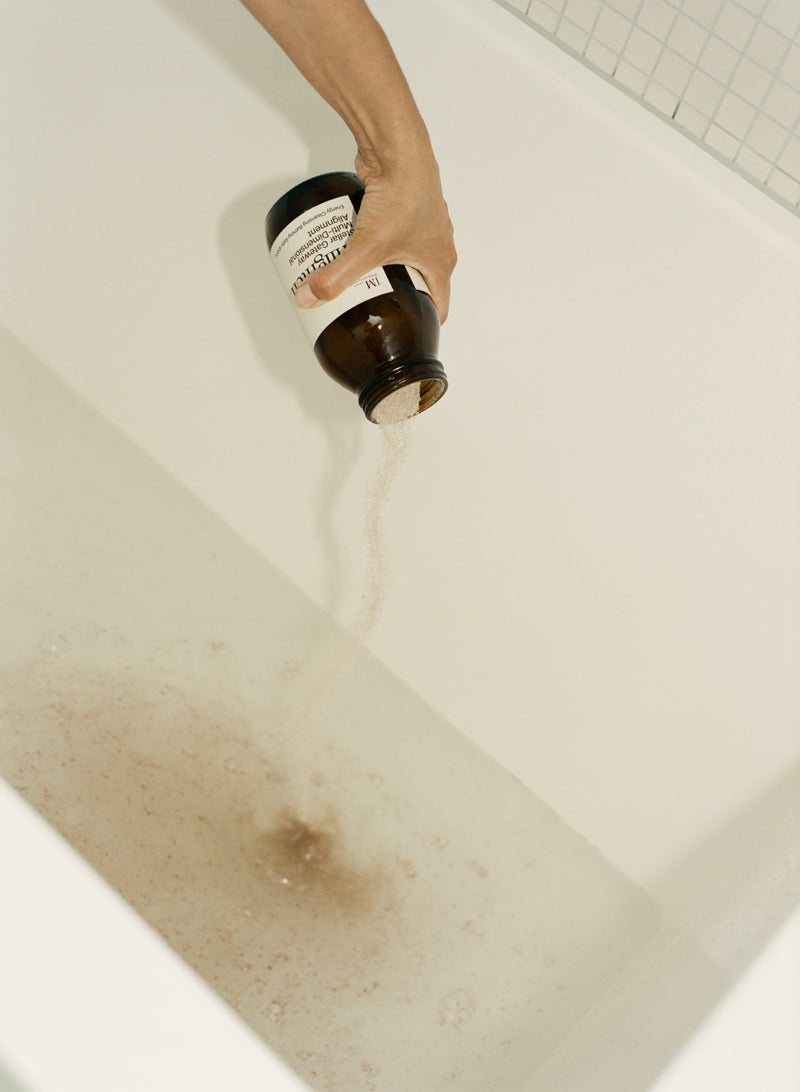 Enlighten bath salts being poured into bath tub 