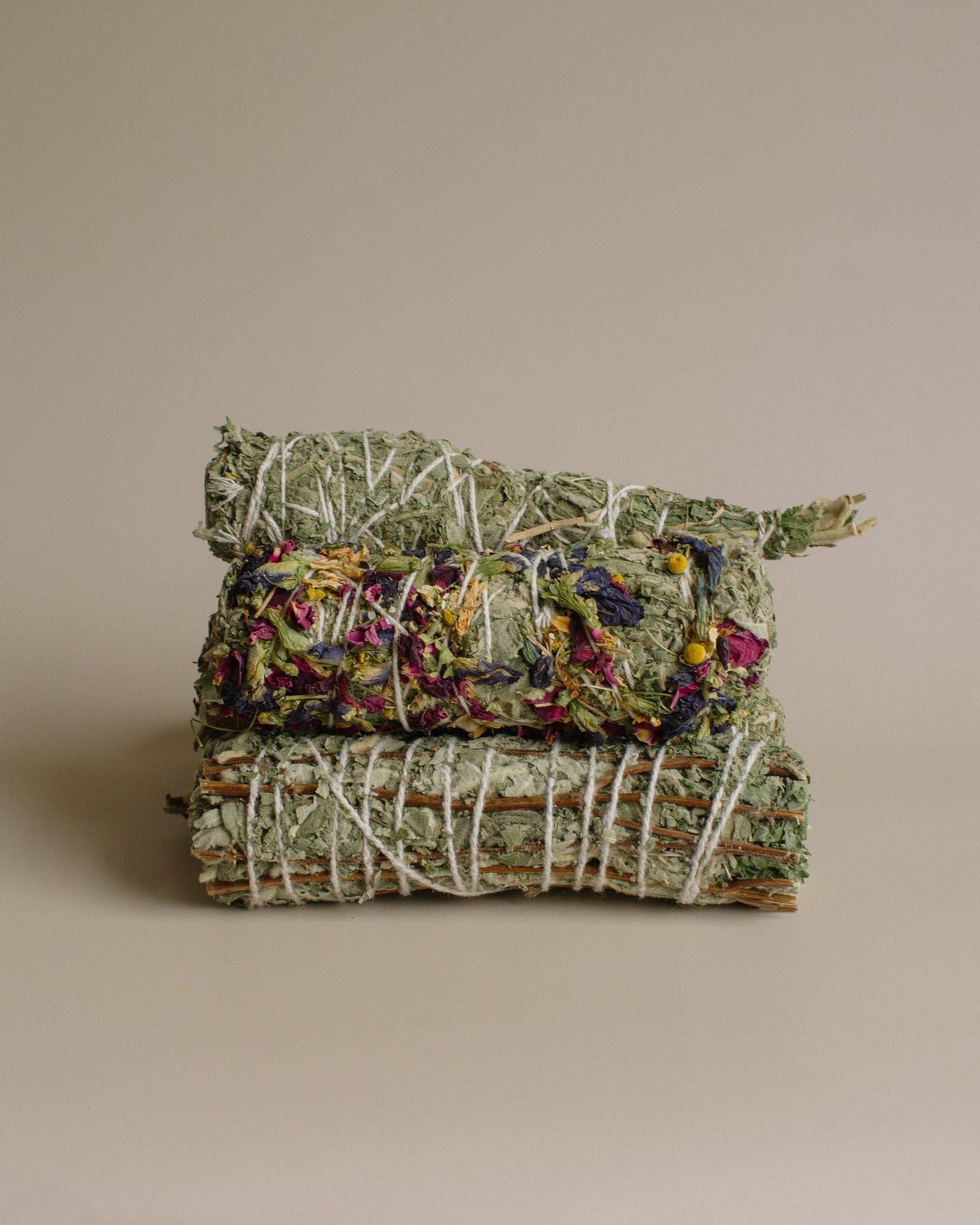 Stack of dried herbs tied together on a beige background