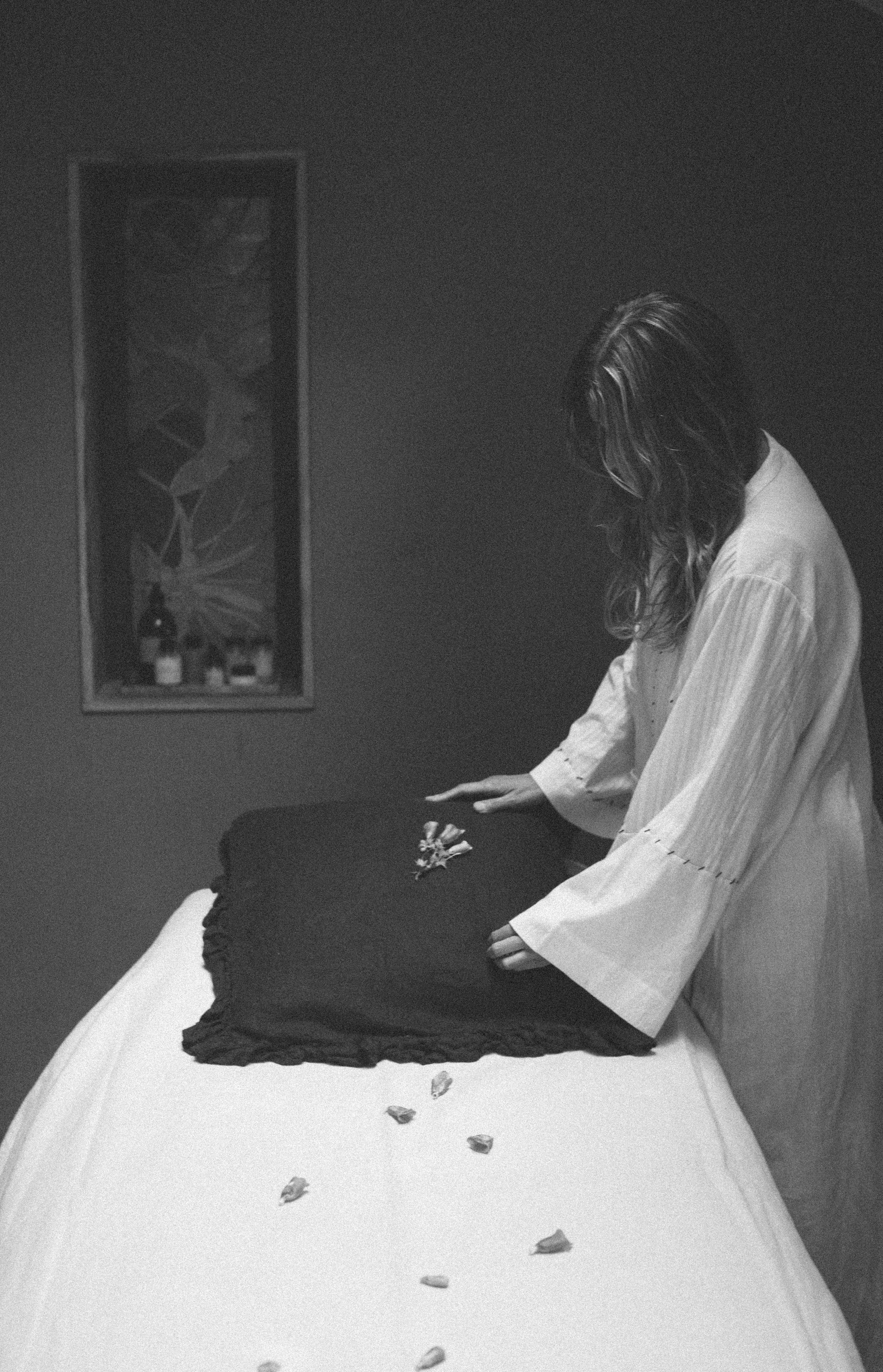 Olivia Crighton Setting up therapy bed with flowers in white dress