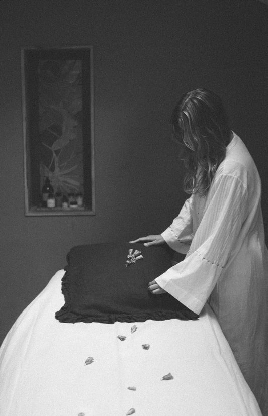 Olivia Crighton Setting up therapy bed with flowers in white dress