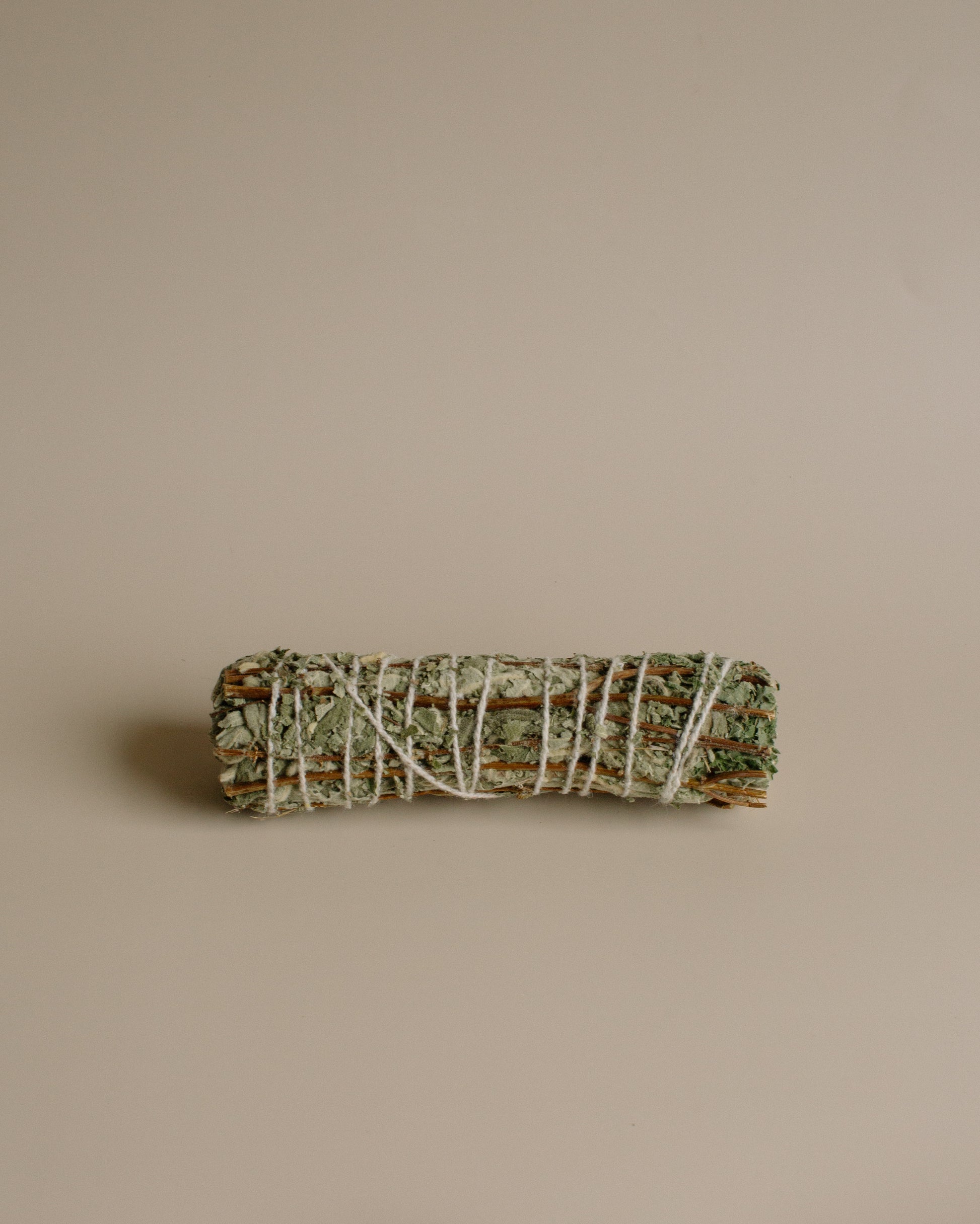 Bundled sage and Tulsi stick on a beige background