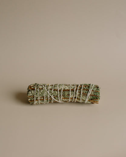 Bundled sage and Tulsi stick on a beige background